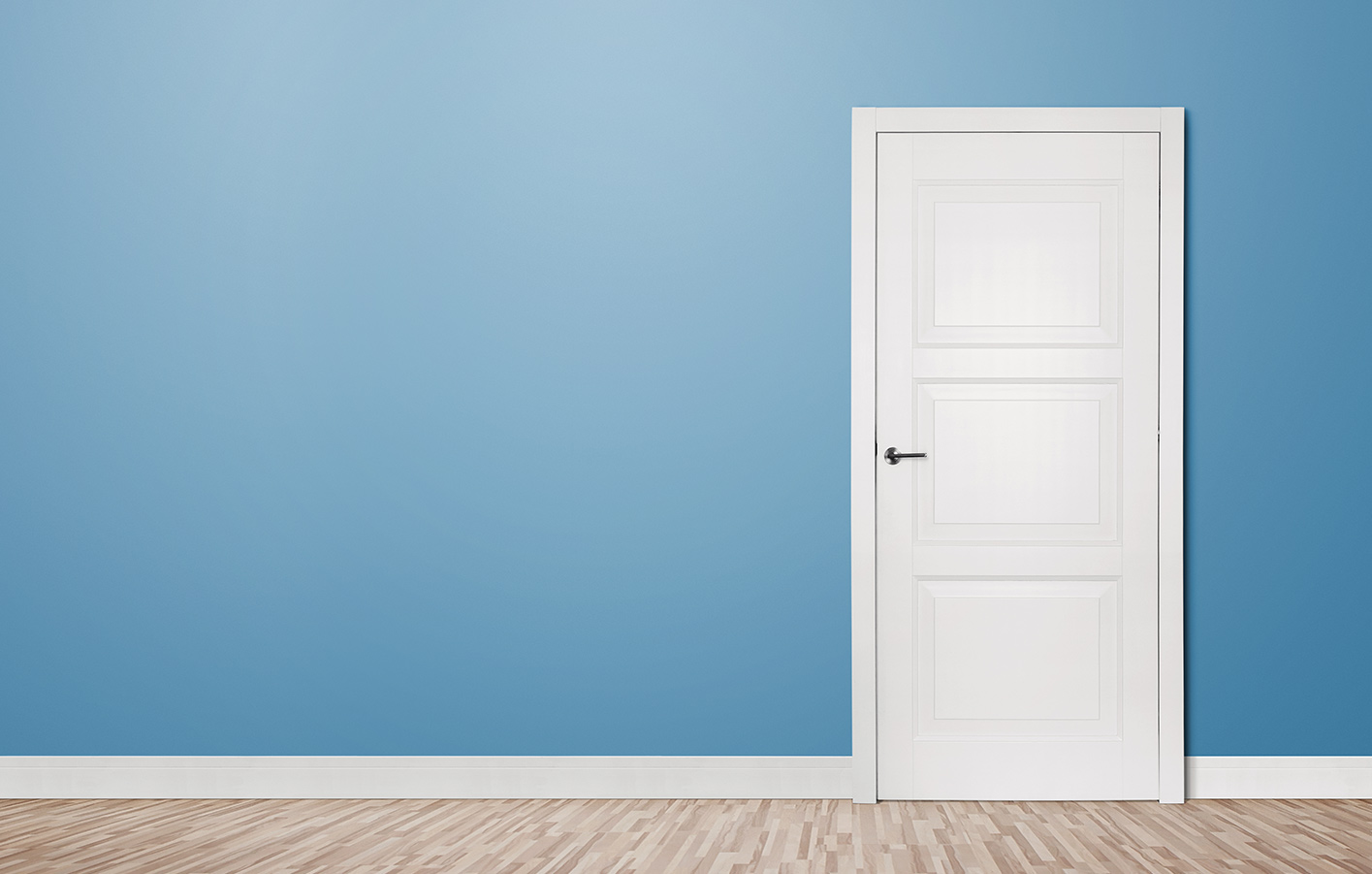 Weiße Zimmertür an einer blauen Wand. 
